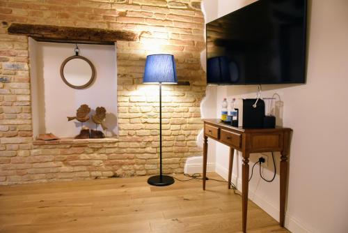 a living room with a lamp and a brick wall at Villa Shmitanka in Servigliano