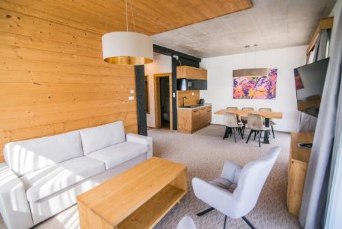 a living room with a white couch and a table at Apartmány Tatry Žiarce in Liptovský Mikuláš