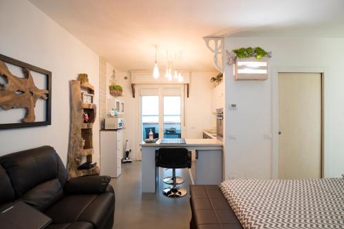 a living room with a couch and a kitchen with a counter at Come sentirsi a casa in Piacenza