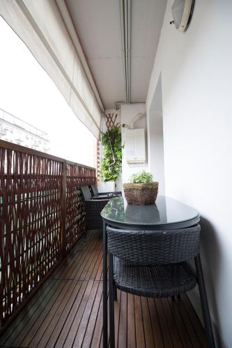 a balcony with a table and chairs on a wooden deck at Come sentirsi a casa in Piacenza