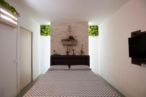 a bedroom with a bed and a wall with two windows at Come sentirsi a casa in Piacenza