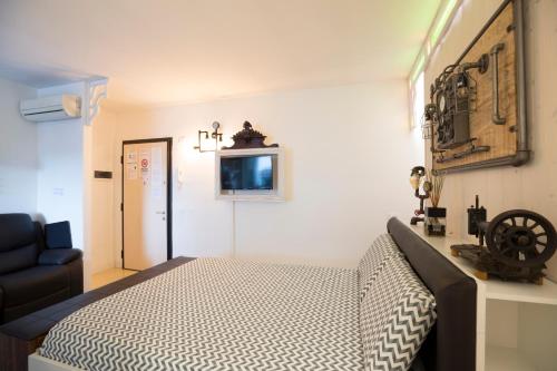 a bedroom with a bed and a chair and a television at Come sentirsi a casa in Piacenza
