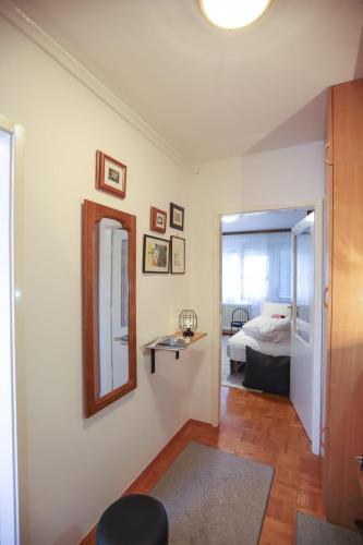 a living room with a mirror and a bed at Apartman ZITA in Osijek