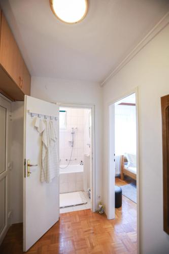 a bathroom with a white door and a bath tub at Apartman ZITA in Osijek