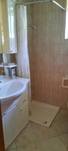 a bathroom with a sink and a shower with a mirror at B&B La casa in Campagna in Ospedaletto