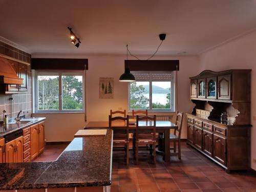 a kitchen with a table and a dining room at Casa Courcelles - Viveiro in Viveiro