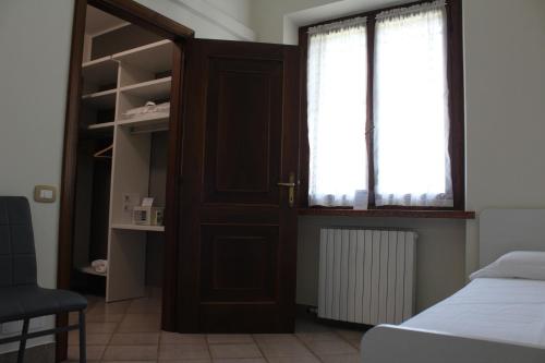 a bedroom with a door and a bed and a window at B&B Villa Verona Bike in Buttapietra