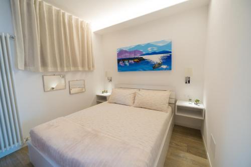 a small bedroom with a bed and a painting on the wall at LAKE Beth's House in Brenzone sul Garda