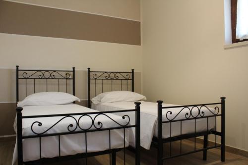 two beds in a room with white sheets and pillows at B&B Villa Verona Bike in Buttapietra