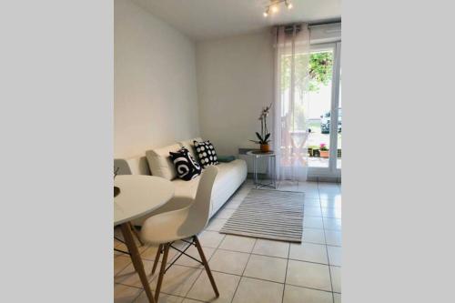 a living room with a couch and a table at Spacious Flat Garden&Parking 5min Basel Tram Bus Airport in Saint-Louis