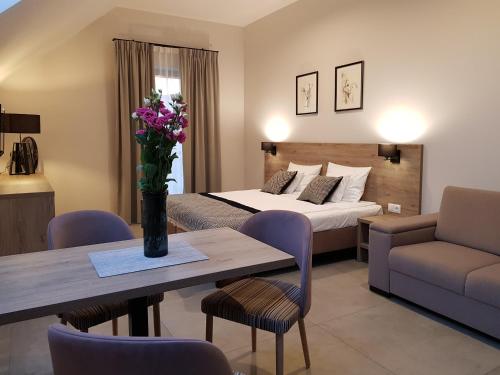 una habitación de hotel con una cama y una mesa con flores en VILLA LIPOVA, en Stegna