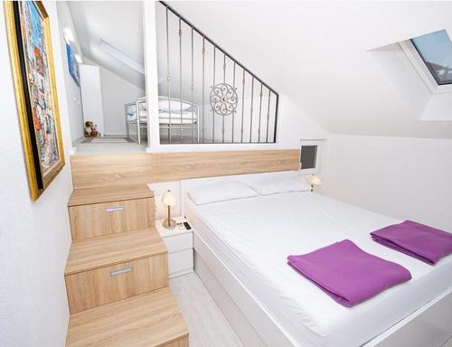 a bedroom with a bed with purple towels on it at Apartmani-Asja in Brist