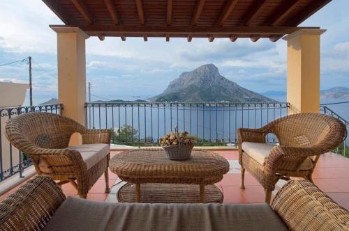patio ze stołem i krzesłami oraz góry w obiekcie VILLA NEXT TO THE SEA!! w mieście Kalimnos
