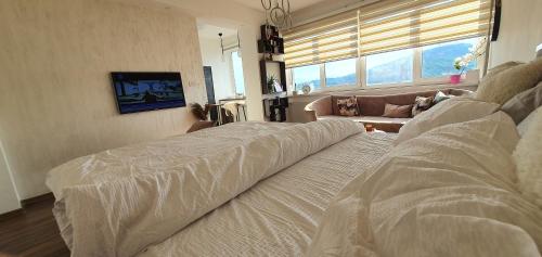Un dormitorio con una cama y un sofá y una ventana. en Green point, en Sarajevo