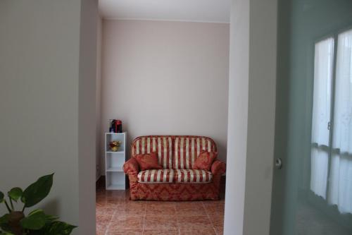 a living room with a red chair in a hallway at B&B Villa Verona Bike in Buttapietra