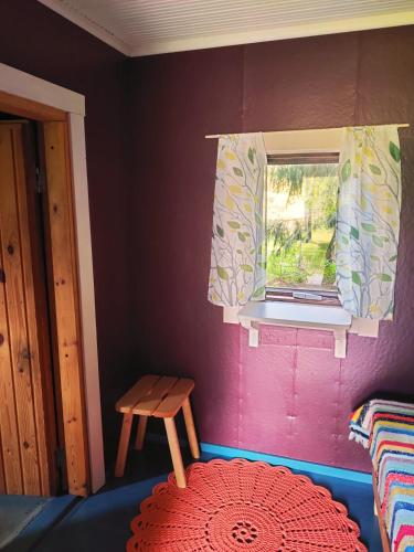 a room with a window and a table and a red rug at Haaran torppa in Mikkeli