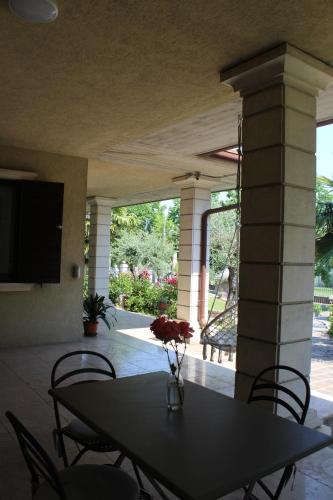 a dining room table with chairs and a television on a patio at B&B Villa Verona Bike in Buttapietra