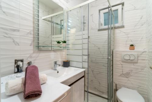 une salle de bain avec lavabo et douche dans l'établissement Villa A Marina, à Marina