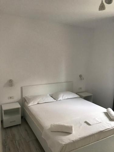 białe łóżko z białą pościelą i poduszkami w obiekcie CasaRiana 4 w mieście Eforie Sud