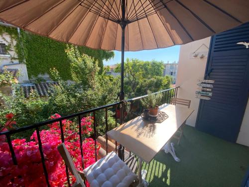 濱海拉塞訥的住宿－Appartement à 150 m de la mer，阳台配有桌子和雨伞。