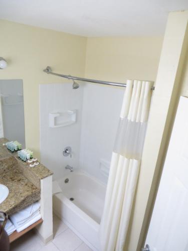 a white bathroom with a tub and a shower at Best Inn & Suites in Anaheim