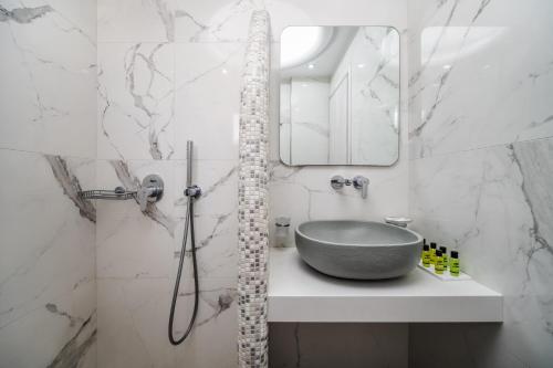 bagno con lavandino e specchio di Emmanouela Studios & Villas a Karterados