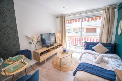 un salon avec un canapé et une télévision dans l'établissement 4 couchages Climatisé Direct Plage wifi parking, à Antibes