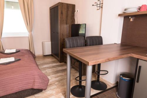 a room with a table and two chairs and a bed at Balkon Apartmanház Panzió in Balatonfüred