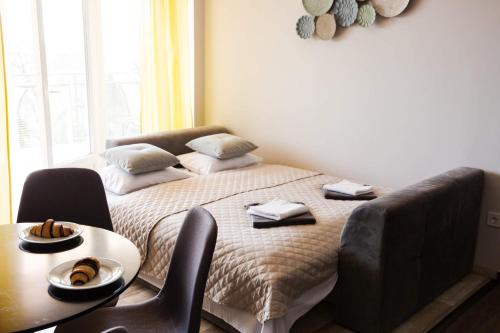 a bedroom with a bed with a table and chairs at Balkon Apartmanház Panzió in Balatonfüred