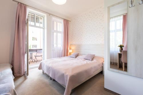 a bedroom with a bed and a mirror at Villa Elizabeth in Kudowa-Zdrój