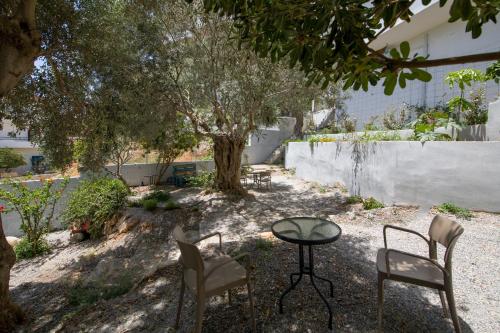 a patio with two chairs and a table and a tree at Eleana Nature & Art in Khóra Sfakíon
