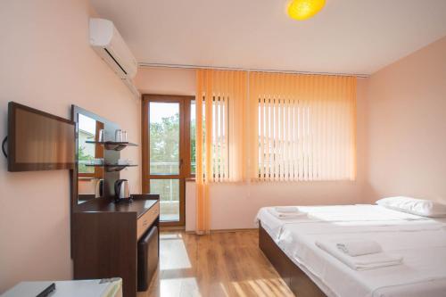 una camera da letto con un letto, una tv e una finestra di Villa Tuna a Sveti Vlas