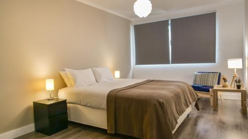 a bedroom with a bed and a large window at São Pedro Apartment in Vila Franca do Campo