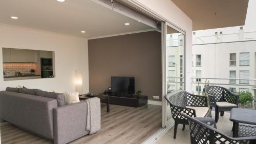 a living room with a couch and chairs and a tv at São Pedro Apartment in Vila Franca do Campo