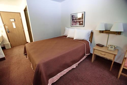 a hotel room with a large bed and a table at Travelodge by Wyndham Elko NV in Elko