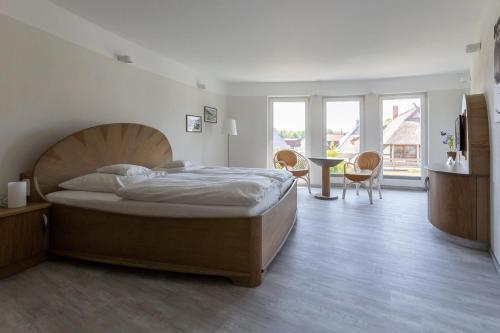 a bedroom with a bed and a table and chairs at Muschel 3 in Ahrenshoop
