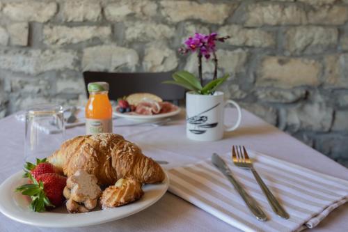 a table with a plate of croissant and a strawberry on it at Cà Piodèe in Faggeto Lario 