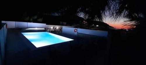 a swimming pool at night with the lights on at Antonios 1 in Matala