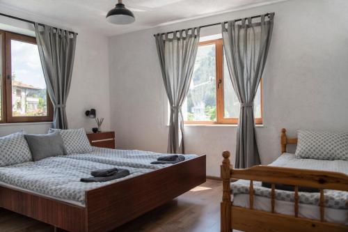 - une chambre avec 2 lits et une fenêtre dans l'établissement Къща До Гората Триград, à Trigrad