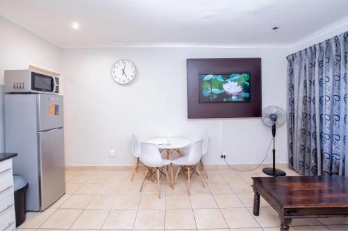 a living room with a table and a refrigerator at Prestigious Apartments in Fourways