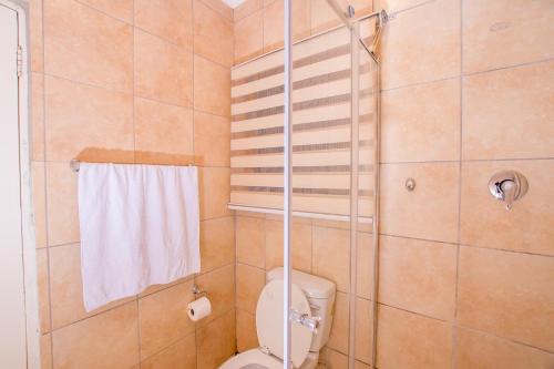 a bathroom with a shower with a toilet and a towel at Prestigious Apartments in Fourways