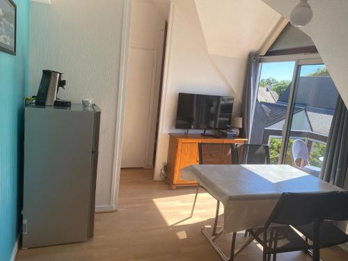 une salle à manger avec une table et une télévision dans l'établissement Confort équipés neuf 2 pas plage, à Carnac