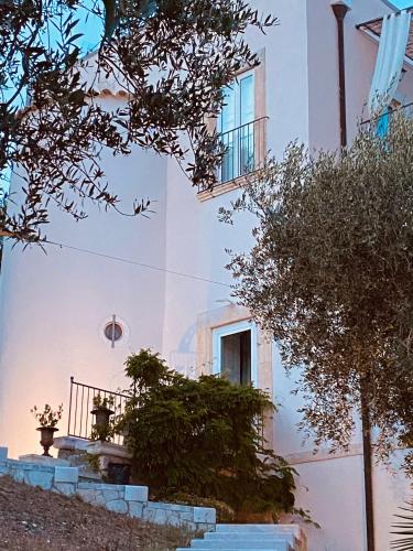 a white building with stairs in front of it at Villa in Gargano - VILLA BASSO in Monte SantʼAngelo