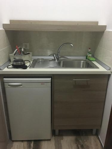 a small kitchen with a sink and a stove at Pansion Vasso in Agios Nikitas