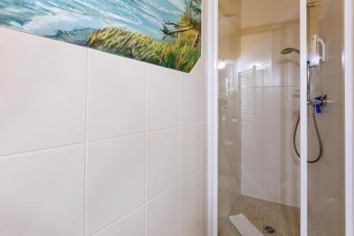a bathroom with a shower and a painting on the wall at Muschel 4 in Ahrenshoop