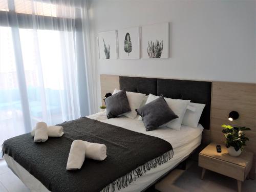 Een bed of bedden in een kamer bij Sunset Waves Luxury Apartment 3 rooms Benidorm