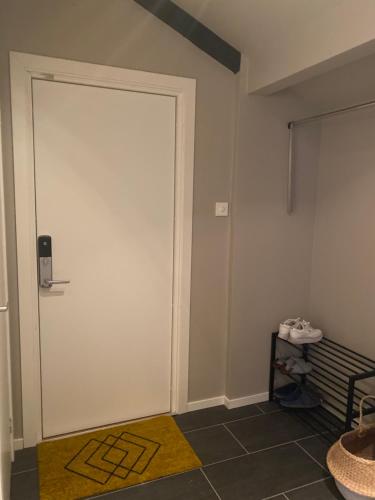 Cette chambre dispose d'une porte blanche et d'un tapis jaune. dans l'établissement Reine City Apartment, à Reine