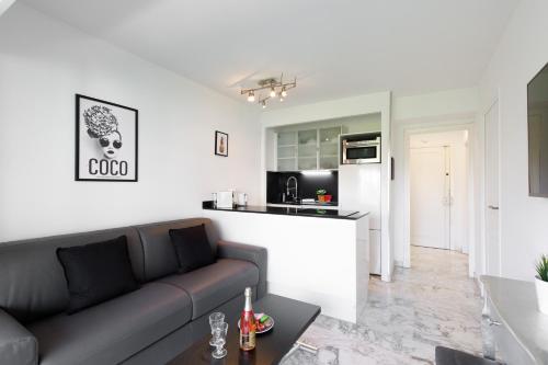 un salon avec un canapé et une cuisine dans l'établissement Phoenix YourHostHelper, à Cannes