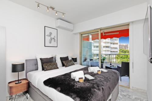 une chambre avec un grand lit et une grande fenêtre dans l'établissement Phoenix YourHostHelper, à Cannes