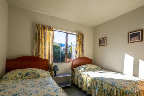 a bedroom with two beds and a window at 11b Leamington Street in Hanmer Springs